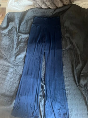 Mörkblå yoga pants  - Säljer ett par mörkblå yoga pants från Kappahl med utsvängda ben. De är mjuka och stretchiga, perfekta för en avslappnad och trendig look. Passar dig som gillar bekväma men ändå snygga byxor. Används någon enstaka gång💓 är i storköket 158/164