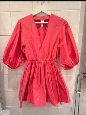 Rosa/coral kortklänning med puffärmar - Jätte söt rosa/coral kortklänning med v-ringning och puffiga trekvartsärmar. Klänningen har markerad midja och är luftig och skön🧡🩷jättefin till när man är brun🧡🩷inga defekter 