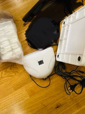 Nagelkit med UV-lampa och elfil - Komplett nagelkit med vit UV-lampa, , dammsugare för nageldamm och ett set med tippar. Perfekt för dig som vill fixa gelenaglar hemma. Allt är i vit plast och har digital display på lampan. Passar både nybörjare och proffs.