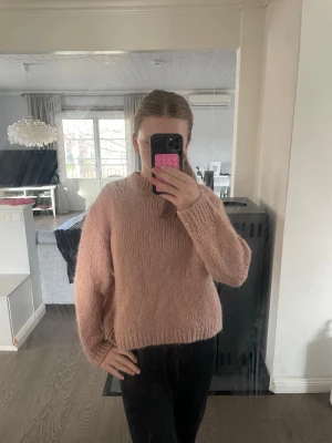 Rosa fluffig stickad tröja - Mysig stickad tröja i en mjuk, fluffig rosa nyans. Tröjan har en rak passform, ribbad rund halsringning och långa ärmar.