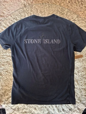 Stone Island T-shirt - Stilig T-shirt från Stone Island i fint skick. Mått: Axel-Axel:45cm | Armhåla-Armhåla: 49cm | Axel-Midja: 64cm | Skriv vid intresse, Skambud undanbedes
