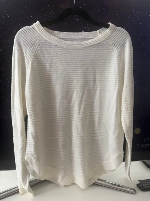 Vit tunn stickad tröja från ONLY strl M - Säljer en tunnare vit stickad tröja från ONLY med diskreta horisontella ränder i strukturen. Tröjan har rund halsringning, långa ärmar och en avslappnad passform. Perfekt att matcha med jeans eller kjol för en clean look. Knappt använd. Strl S