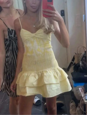 Gul volangklänning  - Söt gul kortklänning med smala axelband och volangdetaljer. Klänningen har en lätt rynkad byst, figurnära passform upptill och två lager volanger i kjolen. Perfekt för varma dagar och har en somrig vibe. Passar storlek xs-s och har justerbara band💕