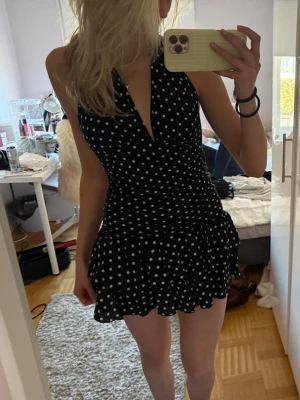 Svart prickig kort klänning - Säljer en svart kort klänning med vita prickar och v-ringad hals💕 