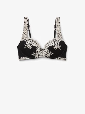 Svart spets-bh från intimissmi - Elegant svart bh med vit spetsbrodyr över kuporna och axelbanden. Bh:n har bygel och tunna axelband, vilket ger ett lyxigt och feminint intryck. Perfekt för dig som gillar detaljer och kontraster. Materialet är en kombination av spets och mjuk textil.