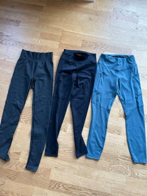 Tre par tights för träning strl xs/s - Tre par träningstights i olika färger: ett par mörkgrå med bred ribbad midja, ett par svarta med slimmad passform och ett par gråblå med sidofickor och reflekterande detaljer. Märke: lager157, soc, new apparal. Dom svarta i mitten ser man baktill att märket är borttvättat, se sista bilden. Övriga 2 par knappt använda.