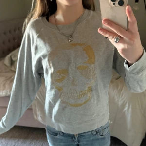 Zadig voltaire tröja - Snygg grå sweatshirt med ett stort guldfärgat dödskalletryck på framsidan från Zadig voltaire!!