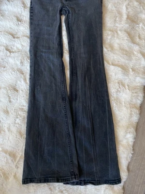 Svarta bootcut jeans med utsvängda ben - Säljer ett par svarta bootcut jeans med riktigt utsvängda ben. Jeansen har klassisk femficksdesign och är gjorda i denim med en tvättad look. Perfekta för dig som gillar retrostil och vill ha ett par jeans som sticker ut. Storlek xs , pris 30kr