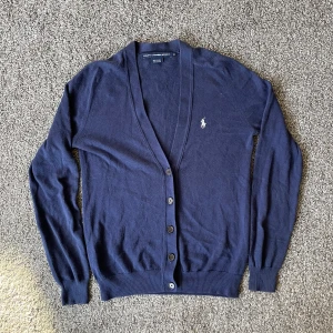 Ralph lauren stickad cardigan - Riktigt snygg stickad cardigan från Ralph lauren, knappt använd. Den sitter som en XS i storleken eller ungefär runt 170