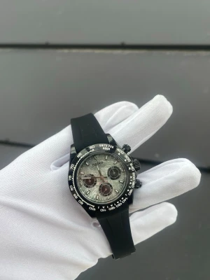 Seiko Daytona Mod - Specifikationer: Storlek: 39mm Urverk: VK63 (Mechaquartz) Material: 904L Rostfritt Stål Svart Glas: Sapphire Glas Tavla: Metroid Bezel: Svart Armband: Viklås och Justerbart  Krona: Screw Down Vattentålighet: 30 Meter Klocklåda ingår