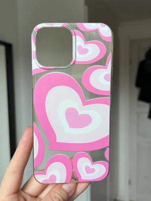 Y2K mobilskal med rosa hjärtan (iPhone 13 Pro Max) - Y2K mobilskal med stora och små hjärtan i rosa och vitt. iPhone 13 Pro Max.