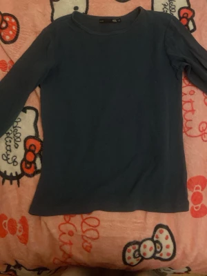 Mörkblå långärmad topp från 157 - En enkel och stilren mörkblå långärmad topp från 157 i storlek XS. Toppen har rund halsringning och är gjord i mjukt bomullsmaterial som känns skönt mot huden. Perfekt att matcha med jeans eller kjol för en clean look.