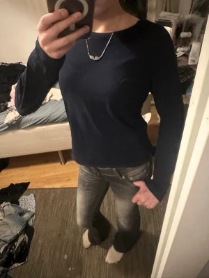 Mörkblå långärmad topp 157 - En enkel och stilren mörkblå långärmad topp från 157. Toppen har rund halsringning och är gjord i mjuk bomull, perfekt för en clean och avslappnad look. Passar till både jeans och kjol för en chill vardagsstil.