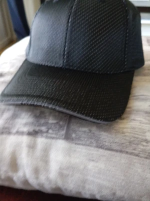 Ny Svart keps  - Snygg svart keps från Blåkläder med diskret prickigt mönster och böjd skärm. Justerbar rem bak med texten 'mekonomen.se'. Perfekt för dig som vill ha en stilren och sportig look.