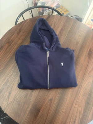 Mörkblå hoodie från Ralph Lauren - Skulle säga att den passar L bättte men original storleken är xl sen har jag dragit ur snörena 