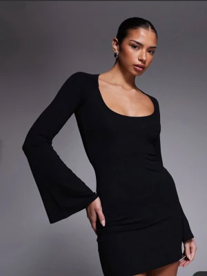 Svart kort klänning med utsvängda ärmar -  Svart kort klänning från Gina  med långa utsvängda ärmar och djup rundringning. Klänningen har en tight passform och är tillverkad i mjuk stretchig polyester som sitter snyggt på kroppen. 