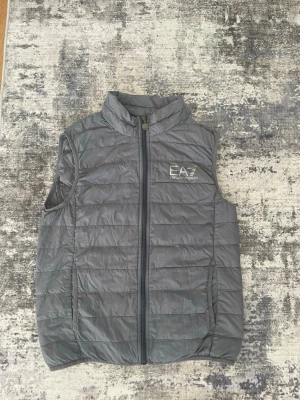 EA7 Emporio Armani väst  - Säljer denna gråaa EA7 västen eftersom den passar inte mig längre och inte använt den på ett tag, Storleken är S , priset kan diskuteras