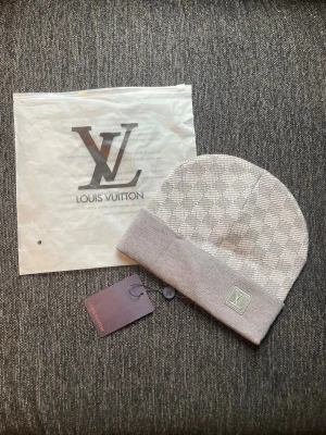 Zara  - Säljer en snygg grå mössa från Zara med klassiskt rutmönster och vikt kant. Den är tillverkad i mjukt stickat material som känns lyxigt och bekvämt. Perfekt accessoar för att lyfta din stil.