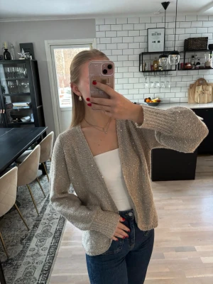 Beige glittrig stickad kofta - Superfin beige stickad kofta med små glittriga paljetter 🌸Köpt i en butik utomlands. Jag är 163 cm. Publicerad på flera säljsidor.