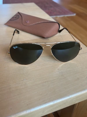 Rayban aviator - Säljer mina solbrillor nu eftersom jag köpt nya. Själva glasögonen är helt nyskick, möjligtvis en ynka repa om man kollar riktigt noggrant. Men tyvärr så är fodralet lite sönder på knappen.