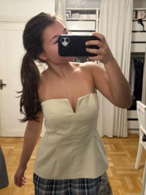 Ljusbeige axelbandslös korsettopp - En jätte fin tube top från Zara. En jätte fin ”slits” mellan brösten. Aldrig använd, passar inte mig. Storlek M. Nypris 270 kr men jag säljer för 200kr🥰