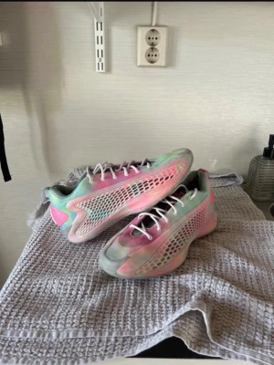 Ae 1 low ”mural” - Säljer ett par riktigt snygga sneakers i pastellfärger med inslag av rosa, mintgrönt och vitt. Skorna har coola meshdetaljer på sidorna och vita skosnören. Låg modell med sportig vibe och syntetmaterial som ger en futuristisk look.