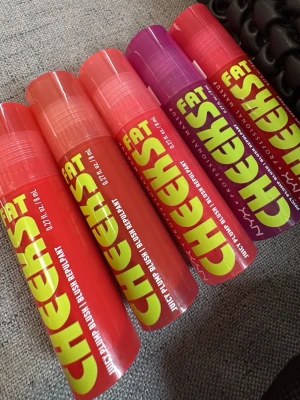 NYX Fat Cheeks Juicy Pump Blush - NYX Fat Cheeks Juicy Pump Blush i flera färger, från korallröd till lila och rosa. Krämrouge i tub med stor applikator, perfekt för att skapa en fräsch och glowig look. Enkel att blanda ut för ett naturligt resultat.