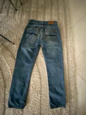 Nudie Jeans - Säljer ett par blå jeans från Nudie Jeans. Modellen heter *Fearless Freddie*            perfekta för dig som gillar en relaxed passform. Storlek: W28 L30  28/30 passar folk runt 165 - 175 inga tecken på användning.