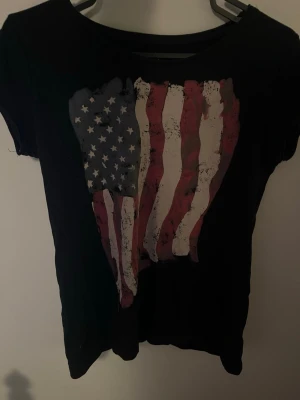 T-shirt  - T-shirt med flagga inga defekter men är i använt sick. Säljer då den inte passar längre