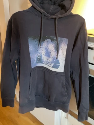 Mörkblå hoodie från Palace med tryck -  hoodie från Palace med stort grafiskt tryck framtill som föreställer deras ikoniska logga med vattendroppar. Passar S
