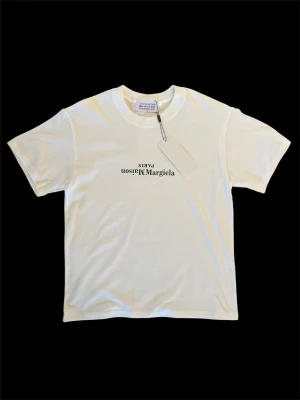 Maison Margiela t-shirt - Säljer denna riktigt snygga och helt nya vita T-shirten med tryck i storlek S. Perfekt nu inför sommaren! Hör av er ifall ni har några frågor! ⭐️