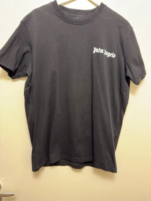 Svart  t-shirt - Svart t-shirt  med klassisk passform och korta ärmar. Tryckt logga i vitt på bröstet. Tillverkad i mjuk bomull som känns skön mot huden. Perfekt för en avslappnad streetwear-look.