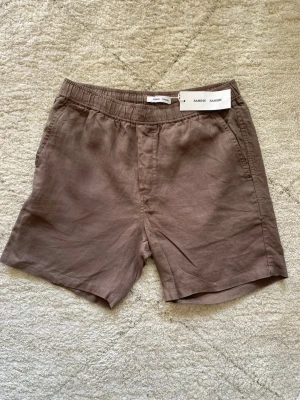 Bruna linneshorts från Samsoe Samsoe - Säljer ett par bruna shorts från Samsoe Samsoe i  linne. Storlek M. Aldrig använt (glömde att returnera). 