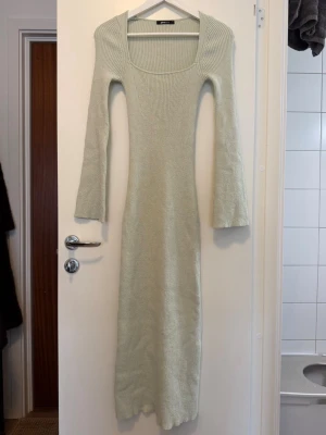 Ljus mint grön/blå ribbad långklänning - Långklänning i ljus nyans med ribbad struktur och lång ärm. Klänningen är figurnära i modellen. Använd endast 1 tillfälle. Perfekt för dig som gillar enkel och stilren design. Inga fler bilder. 
