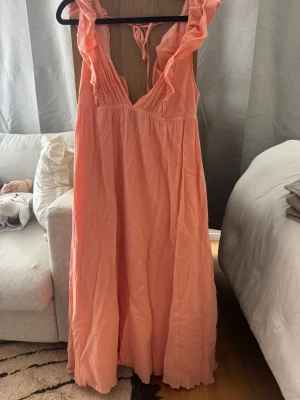Persikoklänning H&M - Eftertraktad persiko / korall färgad klänning från H&M, köpt på Sellpy så det är inte jag som har tagit av lappen. Tror det är strl L men är inte säker. Har två hål på framsidan men inget man tänkt på. 