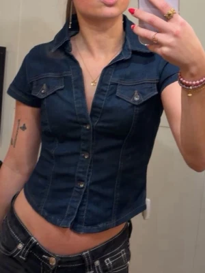 Mörkblå jeansskjorta  - Snygg mörkblå croppad jeansskjorta från Urban outfit. Skjortan har en figurnära passform och klassisk skjortkrage. Ny pris 550kr🤗