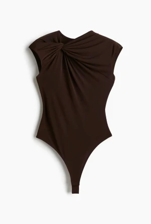 Brun draperad body med axelvikt - Snygg brun body med draperad detalj över axeln och asymmetrisk halsringning. Tillverkad i ett stretchigt, mjukt material som sitter tight mot kroppen. Perfekt för dig som vill ha en trendig och stilren look.