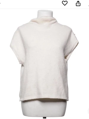 Vit stickad tröja med kort ärm - Mysig vit stickad tröja med korta ärmar och hög krage. Perfekt för lager på lager och enkel att styla till olika outfits. Tröjan har en avslappnad passform och känns både trendig och bekväm.