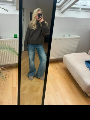 Mörkgrön/brun  stickad polotröja - Mysig grön stickad polotröja med oversized passform och breda ärmar. Tröjan har ribbstickade muddar vid ärmslut och nederkant samt en hög krage. Perfekt för kalla dagar och enkel att styla med jeans eller kjol. Från zara