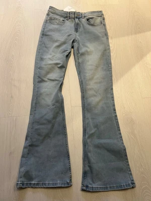 Ljusblåa flare jeans från Gina Tricot - Säljer ett par ljusblåa flare jeans från Gina Tricot, modell 520 Low Flare. Jeansen har klassisk femficksdesign, hög midja och utsvängda ben. Perfekta för dig som gillar retrovibbar och en avslappnad stil.