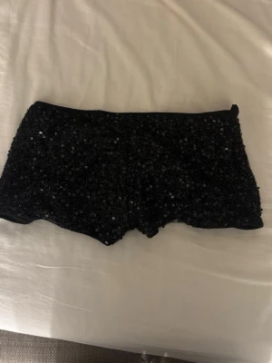 Svarta paljettshorts från SHEIN - Glittriga svarta shorts från SHEIN, täckta med paljetter för en extra festlig look. Gjorda i polyester med en tight passform och kort modell. Perfekta för dig som vill sticka ut och glänsa lite extra.
