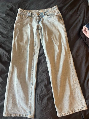 Ljusblå raka jeans från Perfect Jeans - Snygga ljusblå jeans från Perfect Jeans i rak modell. Jeansen har klassisk femficksdesign, bälteshällor och knappgylf. Tillverkade i denim med en skön och avslappnad passform, perfekta för en trendig vardagslook. 