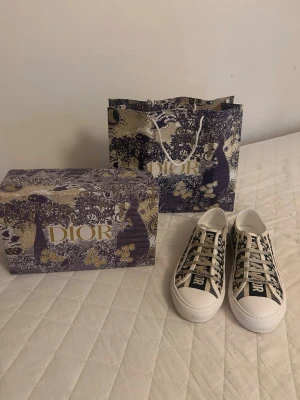 Dior Oblique låga sneakers - Snygga Dior Oblique sneakers i lågt snitt med klassiskt blått och vitt mönster. Skorna har vita snören, gummisula och tydlig Christian Dior-logga på ovansidan. Tillverkade i canvas med exklusiv känsla och levereras med originalkartong och påse.
