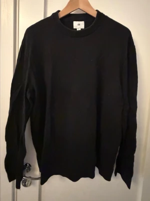 Svart stickad tröja från H&M - En enkel och stilren svart stickad tröja från H&M. Klassisk modell som funkar till det mesta.