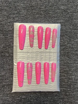 Långa press-on naglar || Storlek M - Snygga långa press-on naglar i en stark rosa färg med glittriga detaljer i guld. Naglarna har en elegant, avsmalnande form och är perfekta för dig som vill ha en trendig look. Finishen är glittrig för extra wow-effekt. Kommer även med ett gulligt färglatt armband 🌸 Storlek M, Det du får med dig : * Fil och manikyr pinne * nagellim klistermärken * 2 lappar av rengöring för naglar.