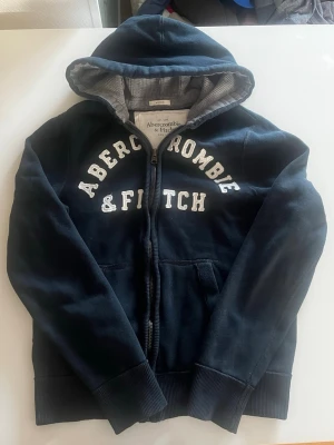 Abercrombie & fitch zip hoodie vintage (eftertraktad) - Riktigt snygg och eftertraktad Abercrombie & fitch zip hoodie. fint skick inga fel storlek L kan ta mått vid behov. Endast 415 ej hugget i sten kom gärna med frågor och prisförslag har även mycket mer liknande i min profil alla storlekar kolla gärna stor rabatt vid köp av flera 😁✌️