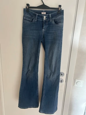 Blå bootcut jeans från Nelly  - Snygga blå bootcut jeans från nelly med klassisk femficksmodell och vita kontrastsömmar på bakfickorna. Jeansen har låg midja. 