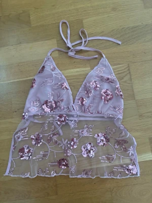 Rosa blommig paljetttopp - Säljer en jättefin rosa festtopp med halterneck. Storlek S. Färgen är egentligen klarare än på bilderna. Jag vet inte vilket märke det är eftersom jag köpte den på Vinted och den tidigare säljaren klippte bort lapparna, men jag gissar att den kommer från Shein eller liknande. 🤍 