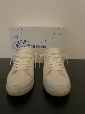 The gallerist -   Säljer ett par snygga vita sneakers från The Gallerist med mjukt foder .perfekta för höst och vinter. Skorna kommer med snygga slitningar från fabrik och är ett par perfekta skor. En stilren modell som passar till både vardag och mer uppklädda outfits. LIMITERADE SKOR. Finns ej att köpa mer.   ✔️ Mjukt och varmt foder ✔️ Bekväma att gå i ✔️ Tidlös vit design ✔️ Originalkartong medföljer  Pris: [2499] kr (nypris 2799kr)   Hör gärna av dig vid frågor eller om du vill ha fler bilder! Kvitto medföljer