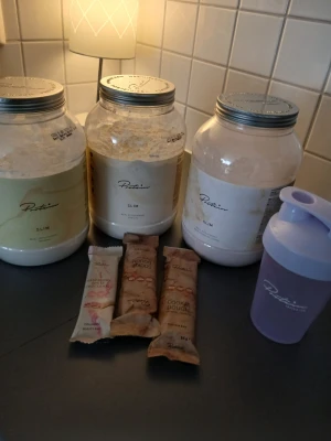 Proteinpulver och shakerpaket - Säljer ett paket med tre stora burkar proteinpulver från Protein.se i olika smaker, fyra proteinbars och en lila shaker. Perfekt för dig som tränar eller vill ha ett smidigt mellanmål. Endast banan och vanilj testad 